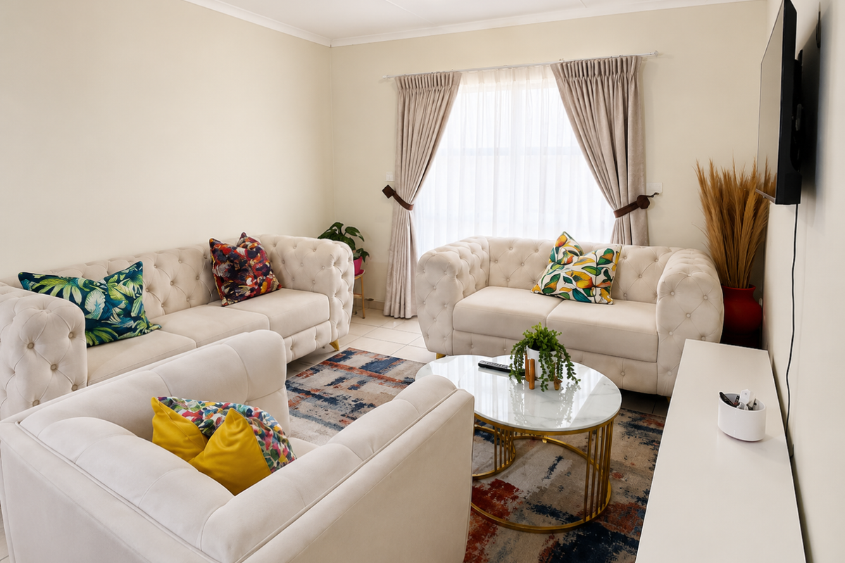 A well-lit living room featuring neutral walls, tiled flooring, and large windows with installed curtain tracks.