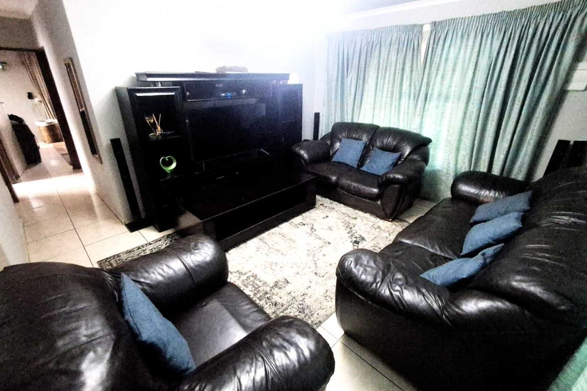 A living room featuring tiled flooring and window treatments, providing a functional space for relaxation.