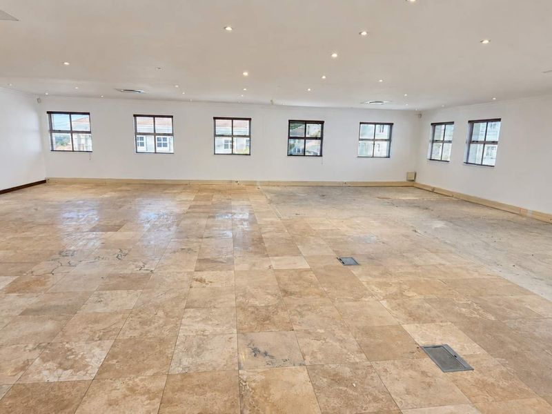 Spacious open-plan office area featuring travertine flooring, recessed lighting, and integrated air conditioning, currently vacant and ready for custom fit-out.