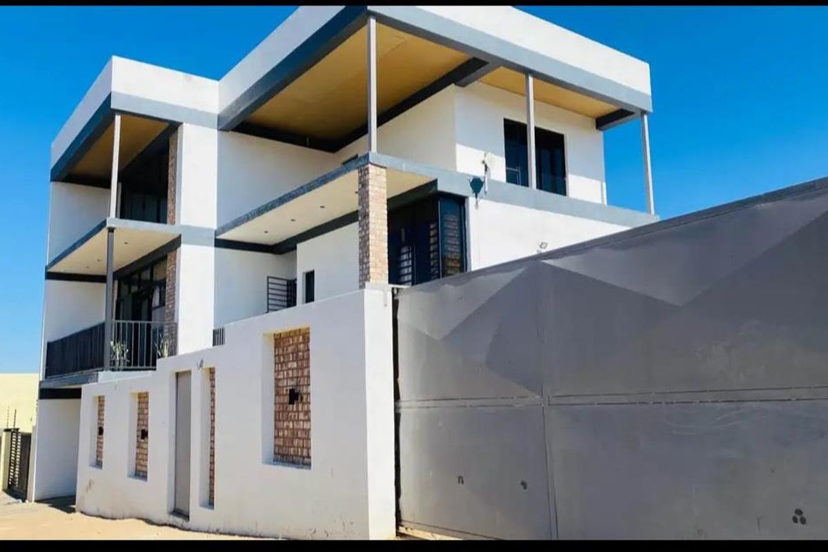 Modern multi-level residential property featuring a contemporary facade, expansive balconies, and a secure gated entrance.