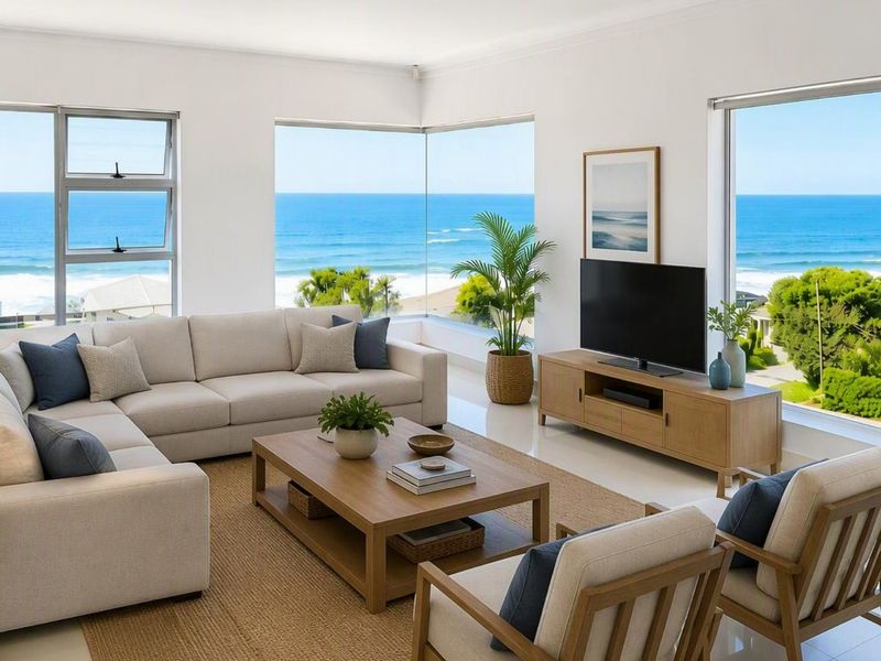 Bright and modern living room featuring expansive corner windows with panoramic ocean views and high-quality tiled flooring.