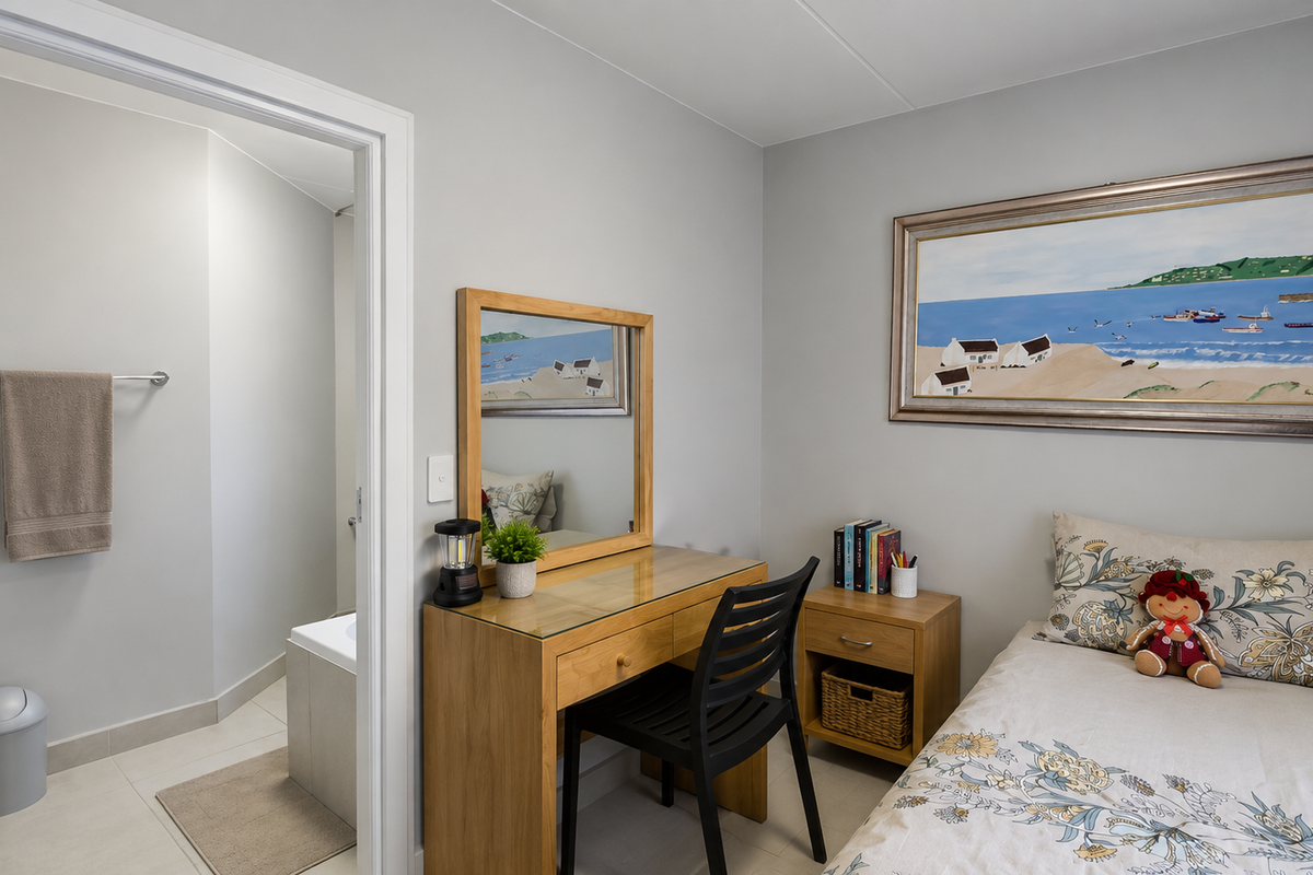 A well-maintained bedroom featuring neutral wall tones, tiled flooring, and an adjoining bathroom entrance.