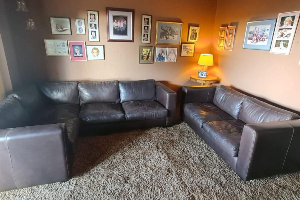 A comfortable living room space featuring neutral wall tones and large sliding glass doors providing natural light access.