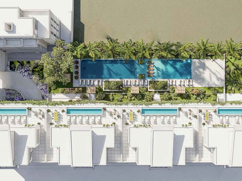 Aerial view of the apartment complex featuring a large communal swimming pool, landscaped gardens, and private plunge pools for ground-floor units.
