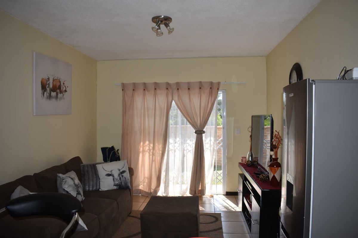 A living room featuring tiled flooring and a sliding glass door providing access to an outdoor area.