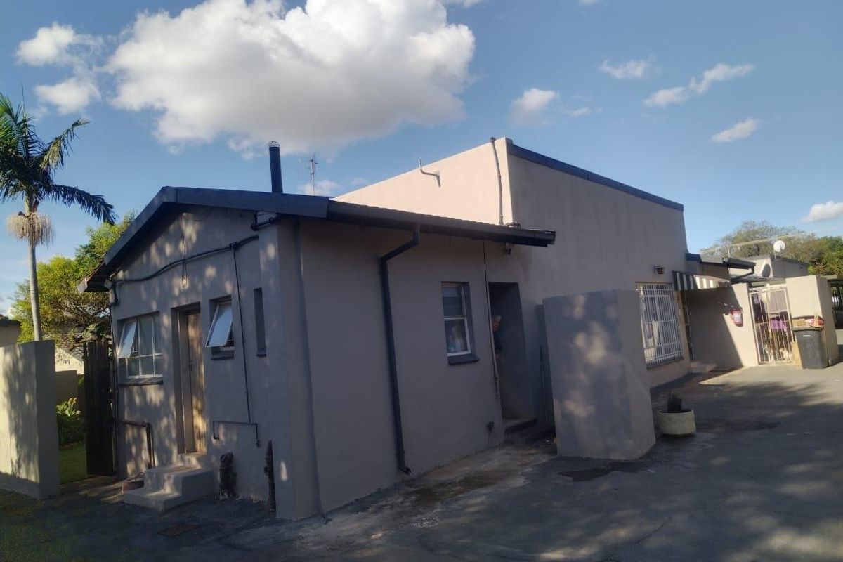 Exterior view of the property featuring a paved driveway, side entrance, and functional guttering system.