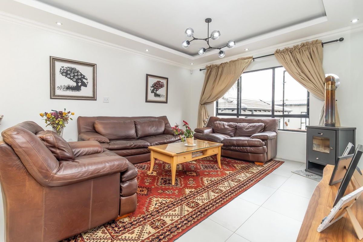 A bright living room featuring tiled flooring, recessed ceiling lighting, and a built-in fireplace, creating a comfortable and inviting space.