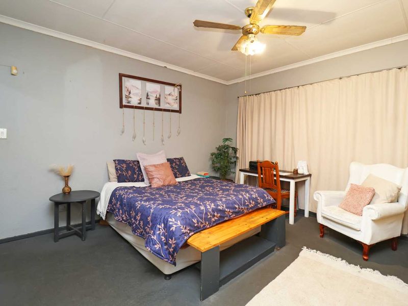 A standard bedroom featuring a ceiling fan and neutral wall finishes, offering a functional space ready for personal updates or modern styling.
