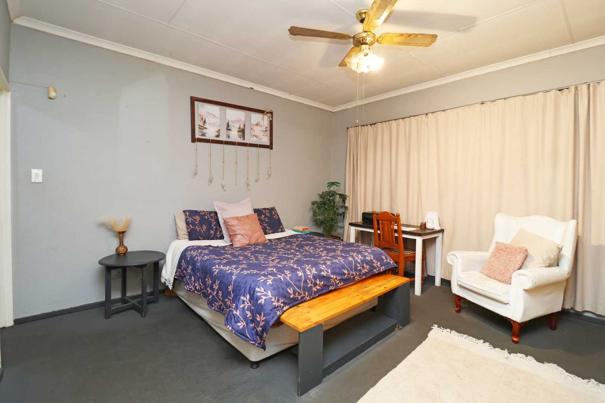 A standard bedroom featuring a ceiling fan and neutral wall finishes, offering a functional space ready for personal updates or modern styling.