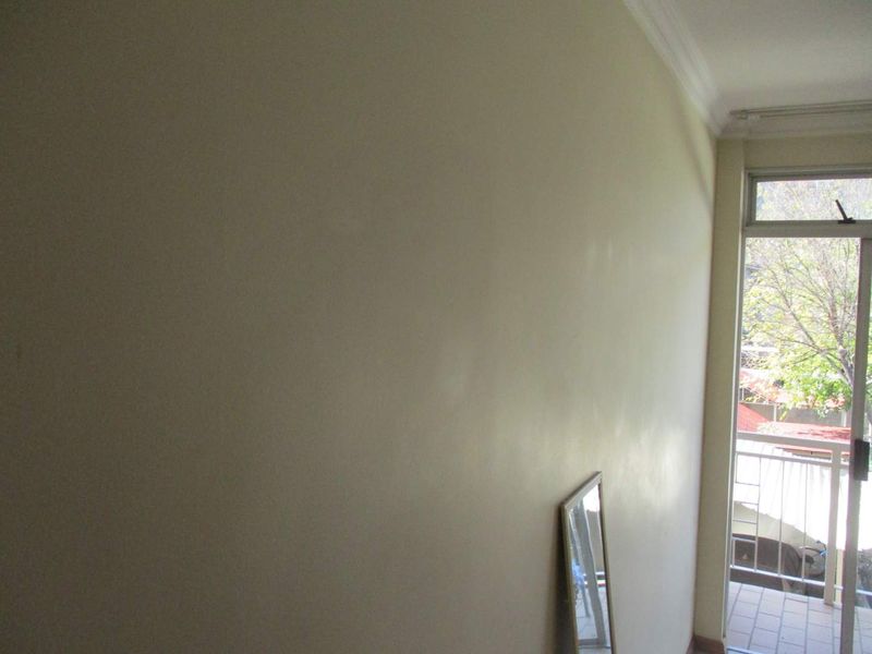 An empty bedroom featuring a sliding glass door that opens onto a small balcony, providing natural light and outdoor access.