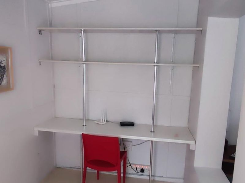 A compact home office space featuring a built-in desk and integrated shelving units, providing a functional workspace.