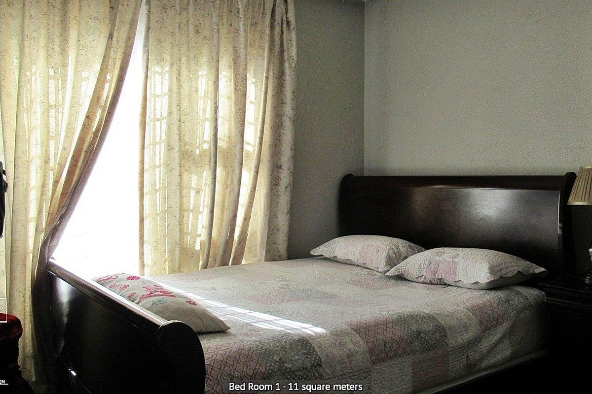 A bedroom featuring natural light through window curtains.