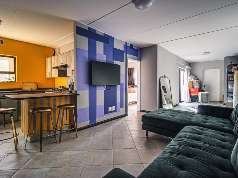 Open-plan living area featuring a kitchen with granite countertops and tiled flooring, seamlessly connected to the lounge space.