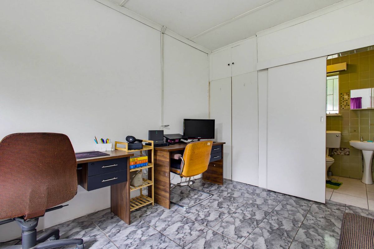 Bedroom featuring tiled flooring, built-in cupboards, and direct access to an en-suite bathroom.