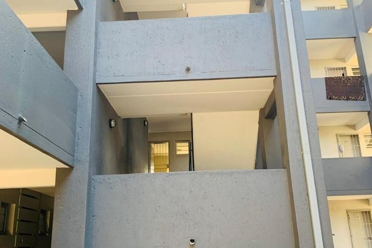 A view of the exterior concrete stairwell and balcony structure of the townhouse complex.