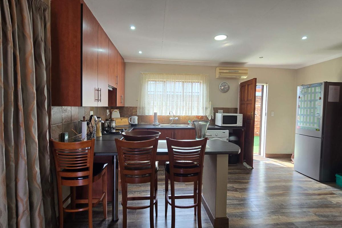 Functional kitchen featuring wood-finish cabinetry, laminate countertops, tiled backsplash, and recessed lighting, with direct access to the exterior.