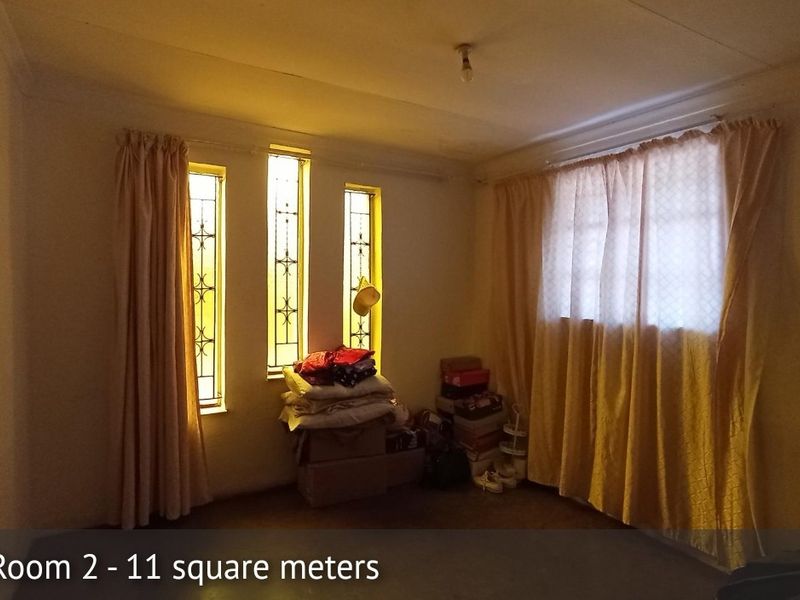 A bedroom featuring security bars on the windows and coving detail, requiring cosmetic updates to improve the overall finish and appeal.
