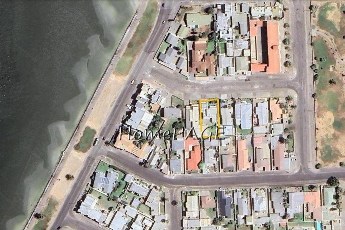 Aerial view of the property location within the coastal residential neighborhood, highlighting its proximity to the waterfront.