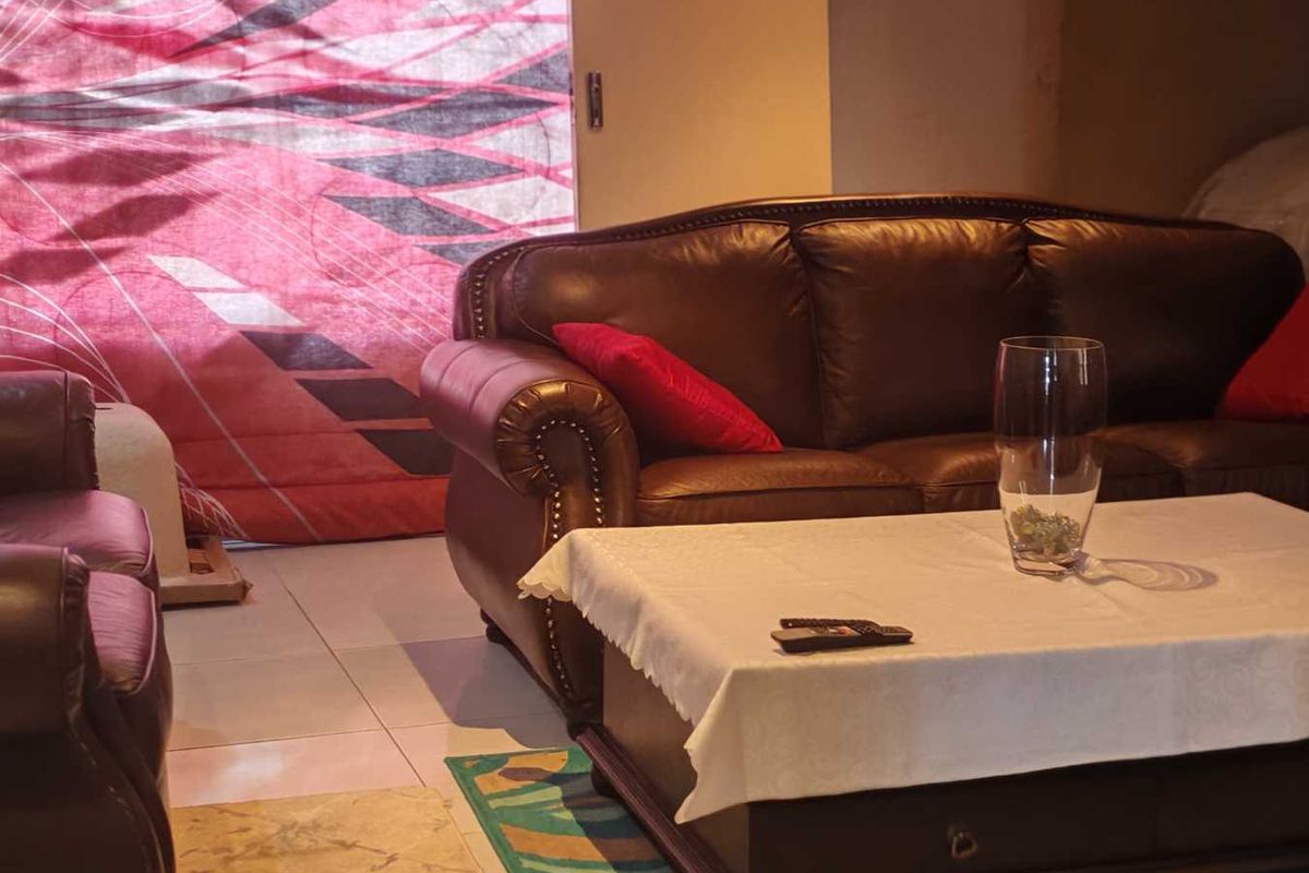 A living room area featuring tiled flooring and neutral wall finishes, providing a functional space for relaxation.