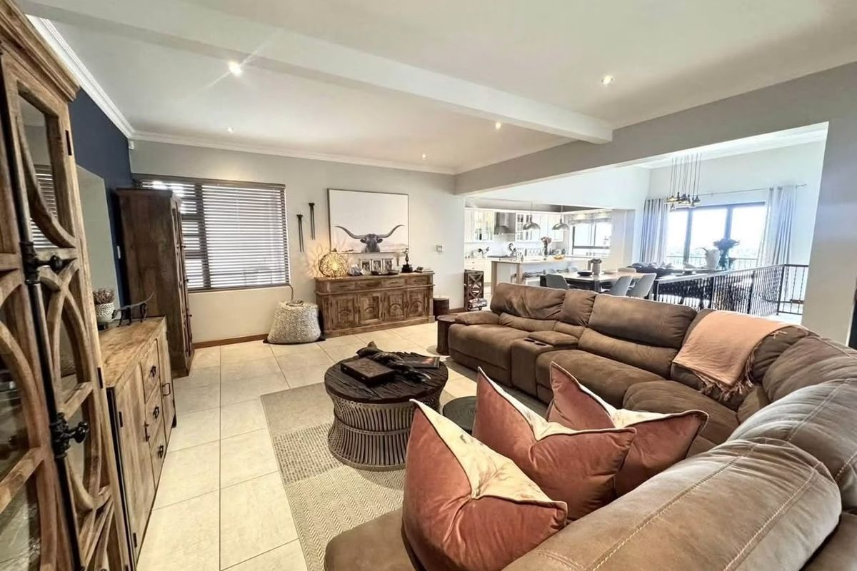 Spacious open-plan living area featuring tiled floors, recessed lighting, and a seamless flow into the modern kitchen and dining space.