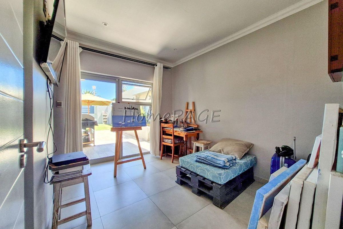 A versatile room featuring large sliding glass doors that provide direct access to the outdoor patio area, finished with neutral floor tiles.