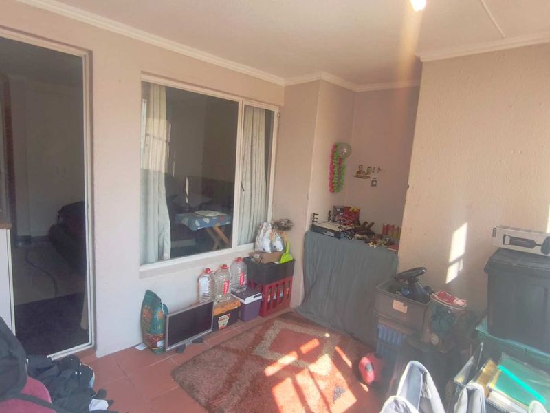 A covered patio area featuring tiled flooring and access to the interior, currently used for storage.