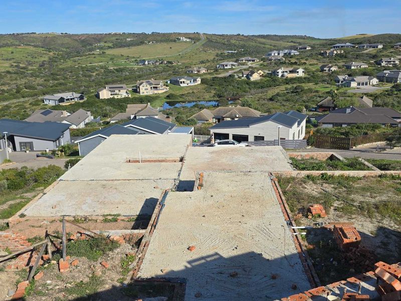 Aerial view of a residential property under construction, showing the concrete slab foundation and surrounding neighbourhood landscape.