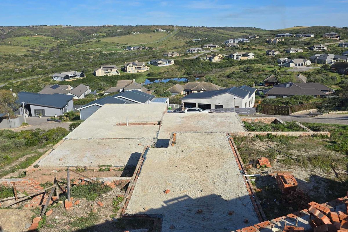 Aerial view of a residential property under construction, showing the concrete slab foundation and surrounding neighbourhood landscape.