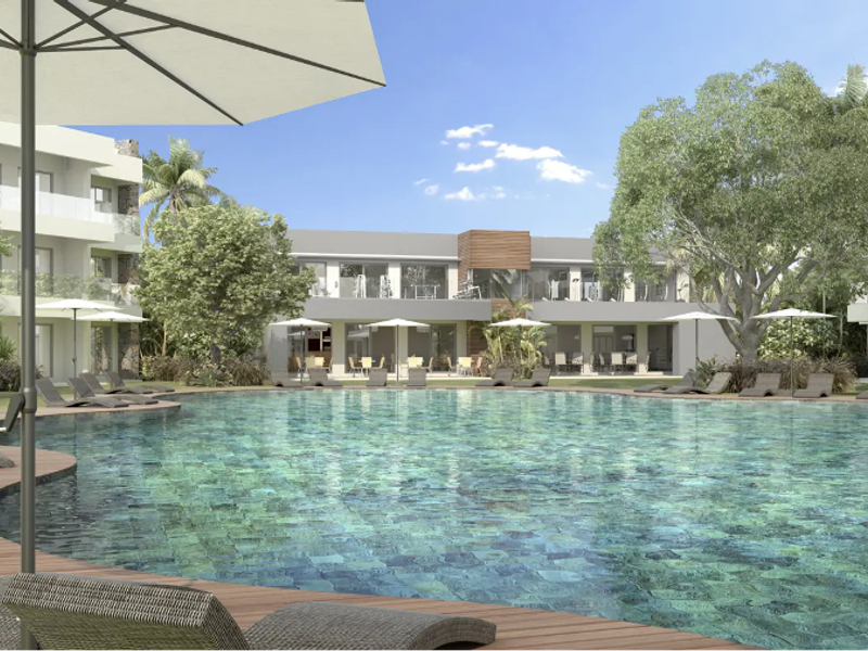 A beautifully landscaped communal pool area featuring a large swimming pool, timber decking, and modern apartment building architecture in the background.