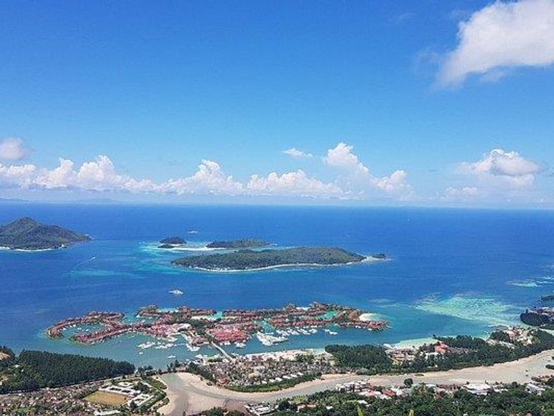 An expansive aerial view showcasing the coastal landscape, surrounding islands, and the turquoise ocean waters.