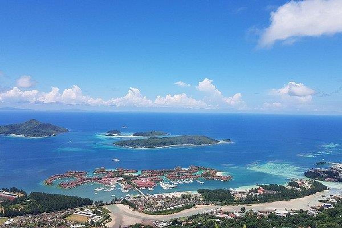 An expansive aerial view showcasing the coastal landscape, surrounding islands, and the turquoise ocean waters.