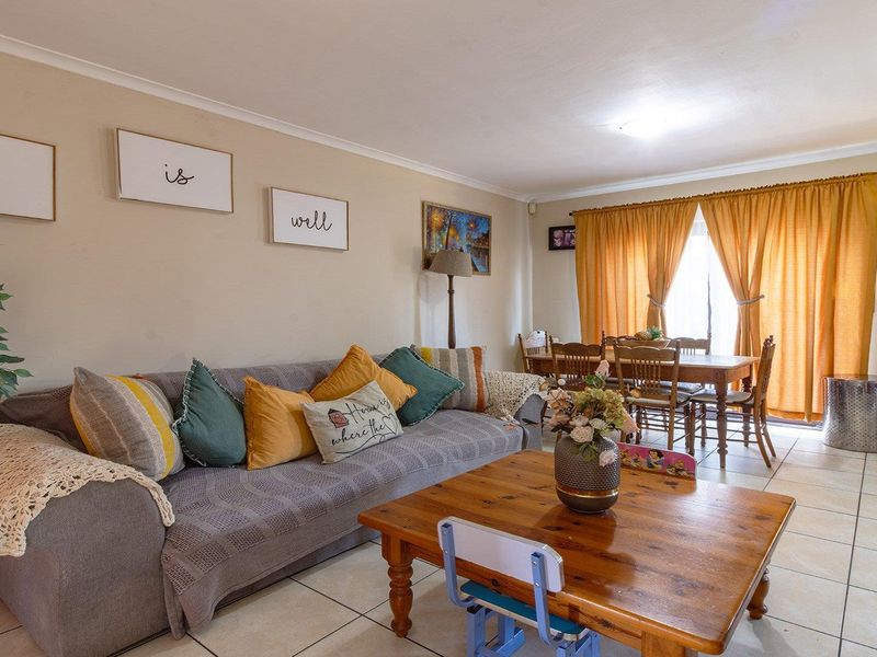 Open plan living and dining area featuring neutral wall tones and tiled flooring, providing a versatile space for family living and entertaining.