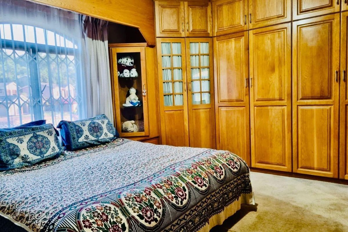 A bedroom featuring extensive built-in wooden cabinetry and integrated display shelving, providing ample storage space and a traditional aesthetic.