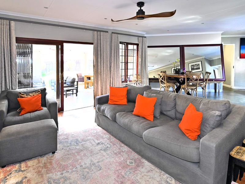 Spacious living area featuring tiled flooring, recessed lighting, a ceiling fan, and large sliding glass doors providing seamless access to the outdoor patio.