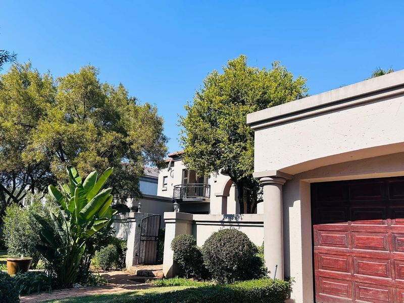 Front exterior view of the property featuring a garage, boundary wall, and a balcony with wrought iron railings.