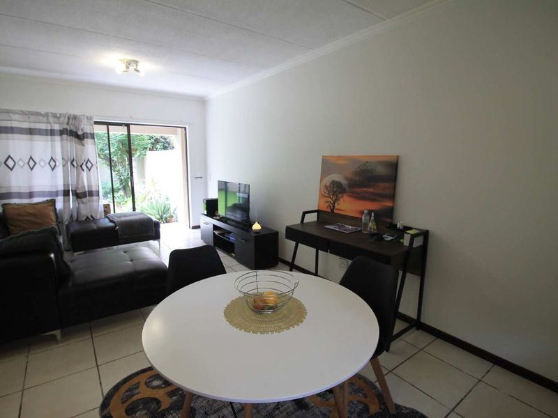 Open plan living and dining area featuring tiled flooring and a sliding glass door providing access to the outdoor space.