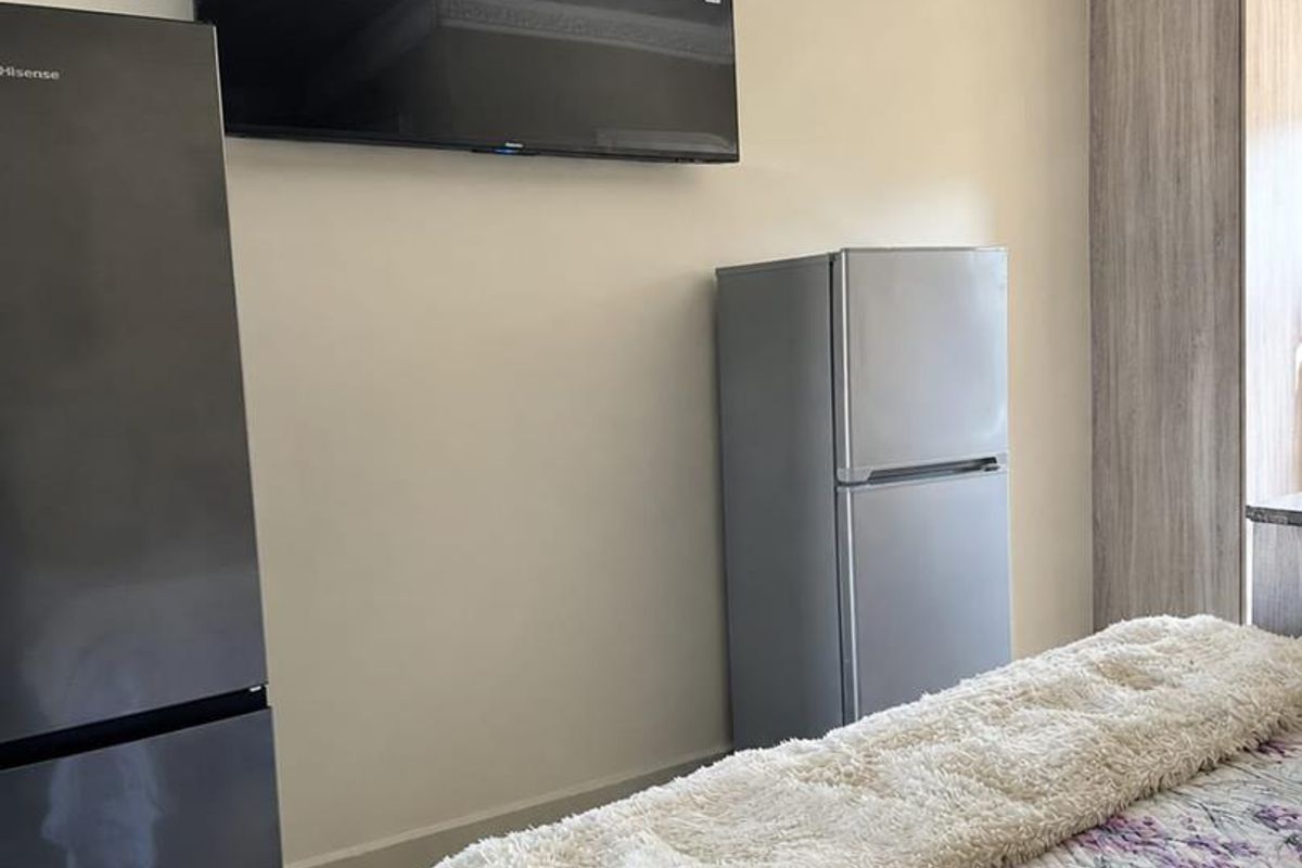 A bedroom featuring built-in wardrobe storage, decorative ceiling cornicing, and patterned ceiling tiles.