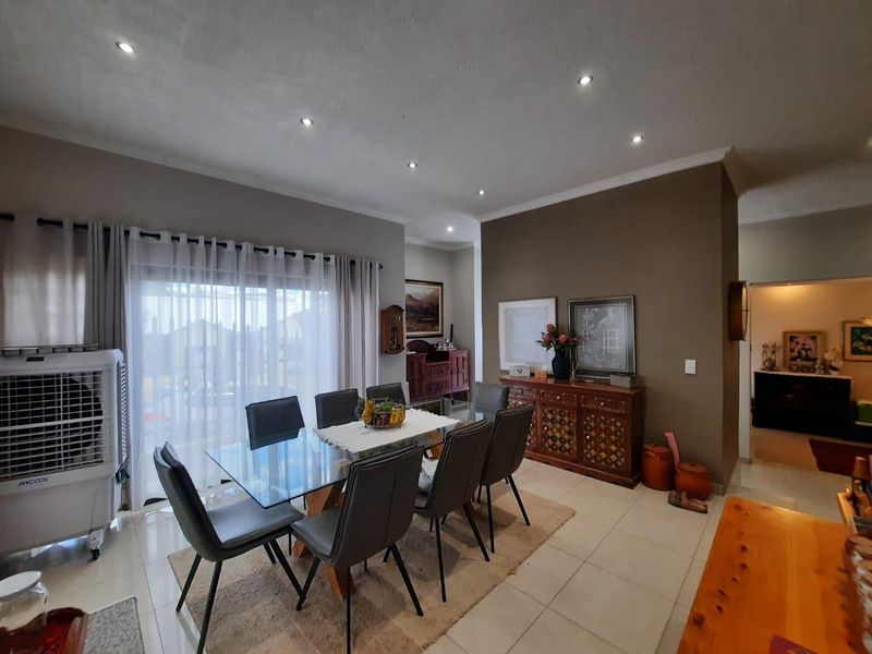 A dining room featuring tiled flooring, recessed downlighting, and a sliding glass door providing access to the exterior.