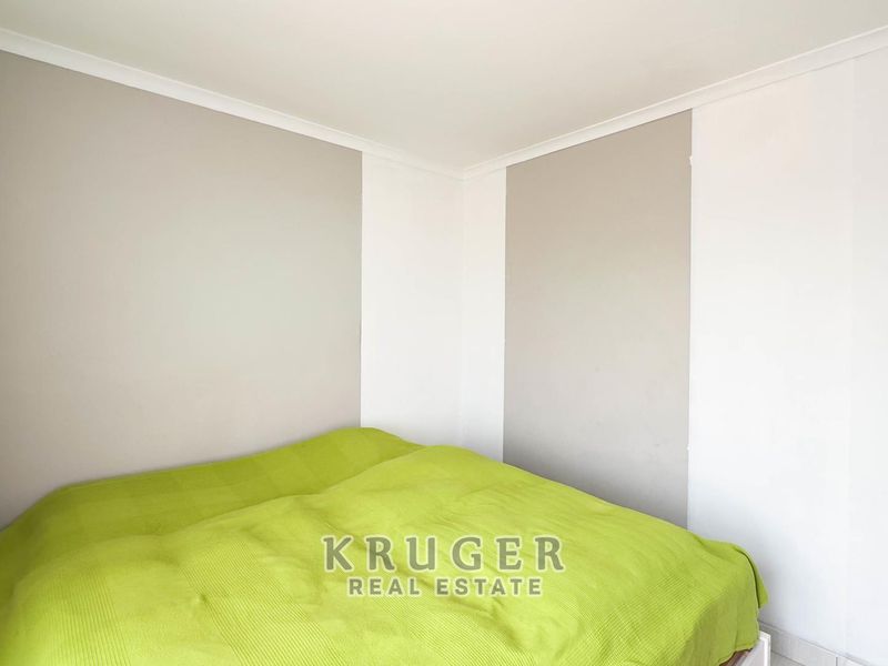 A simple bedroom featuring neutral two-tone wall paint and ceiling coving.