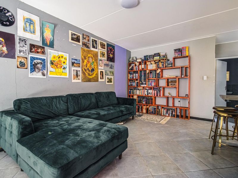 Open plan living area featuring tiled flooring and a built-in breakfast bar, offering a versatile space for relaxation and dining.