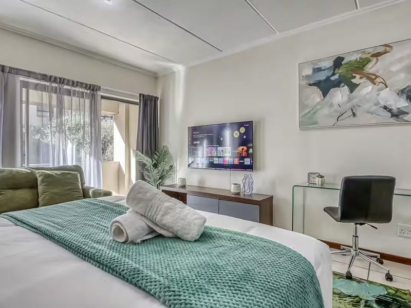 A well-maintained bedroom featuring tiled flooring, a sliding glass door leading to a balcony, and neutral wall finishes.