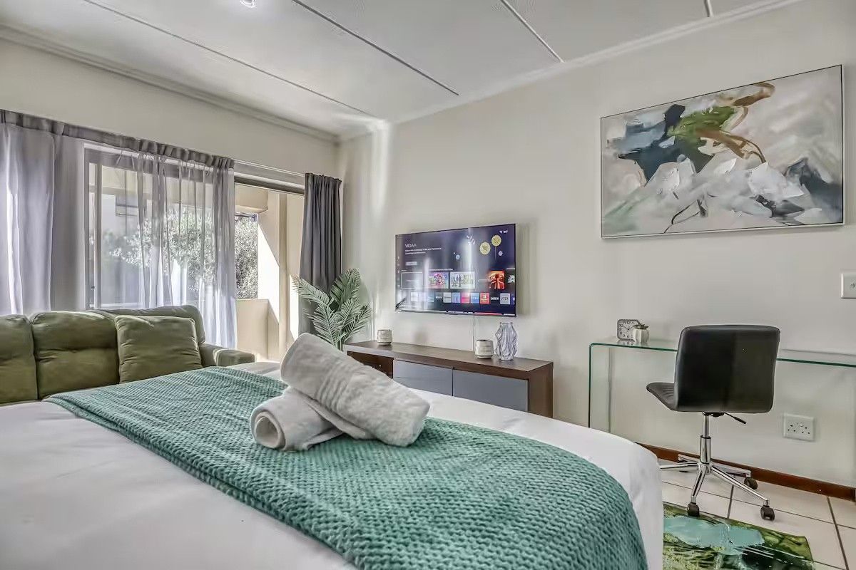 A well-maintained bedroom featuring tiled flooring, a sliding glass door leading to a balcony, and neutral wall finishes.