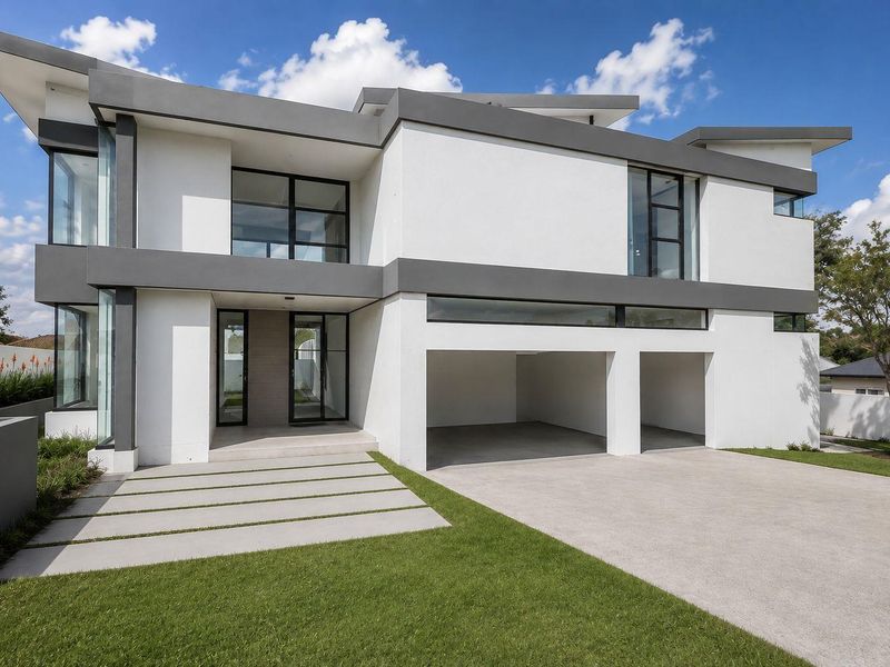 A modern double-story home featuring a sleek white and grey facade, large glass windows, a double garage, and a well-maintained front lawn.