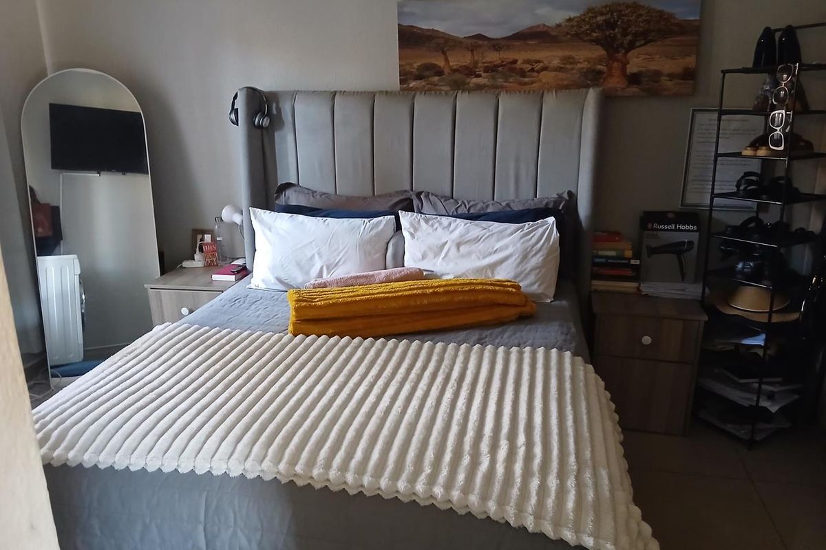 A bedroom featuring tiled flooring and neutral wall finishes, providing a functional and comfortable sleeping space.
