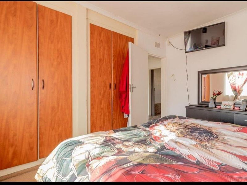 A bedroom featuring built-in wooden cupboards and carpeted flooring, providing functional storage space.