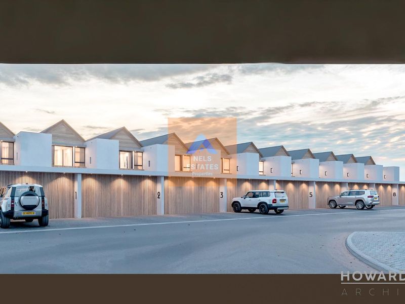A modern townhouse complex featuring a row of garages with timber-slatted doors and contemporary architectural design.