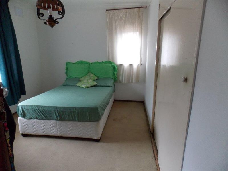A bedroom featuring built-in wardrobe storage and carpeted flooring, requiring cosmetic updates to improve its overall condition and appeal.