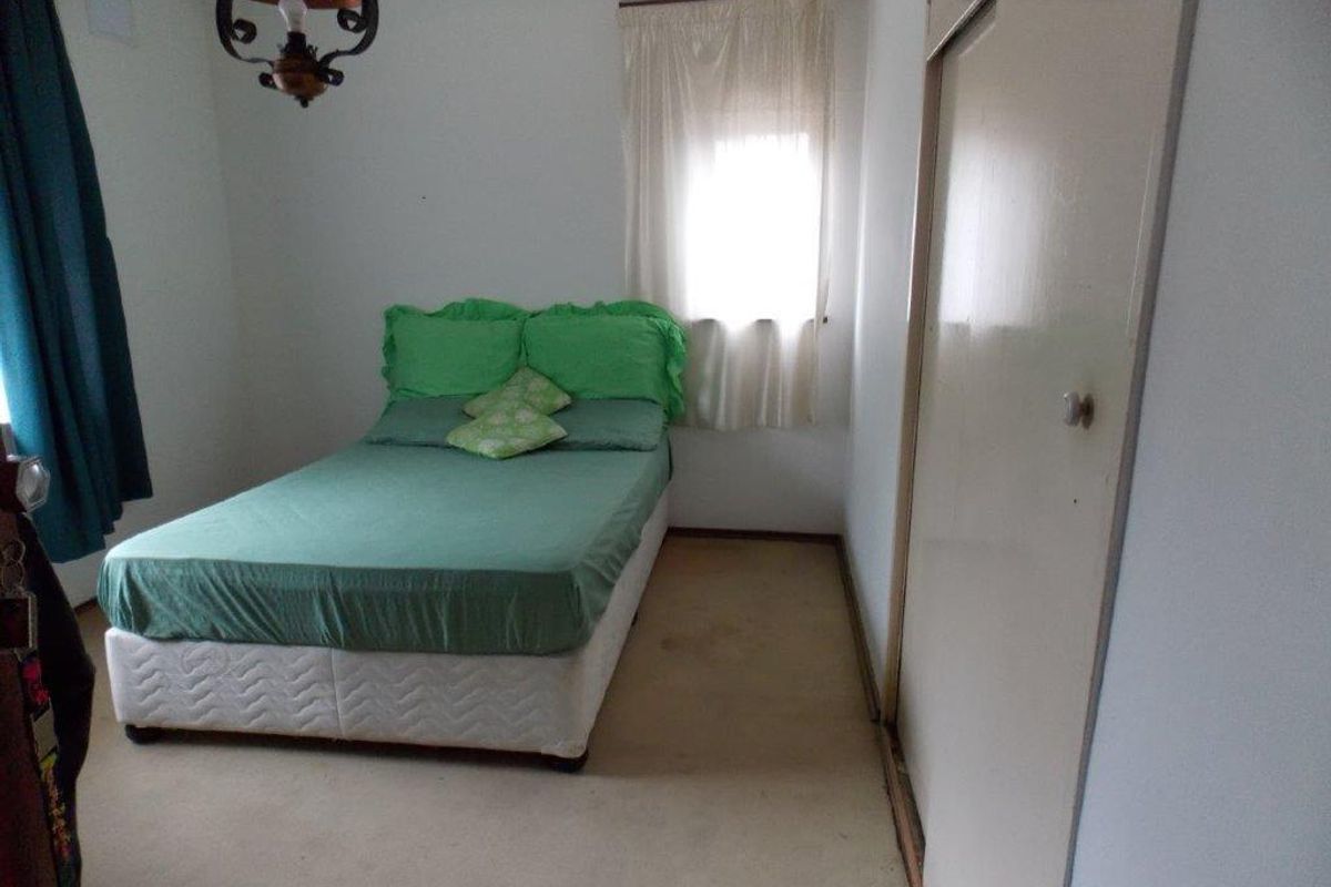 A bedroom featuring built-in wardrobe storage and carpeted flooring, requiring cosmetic updates to improve its overall condition and appeal.