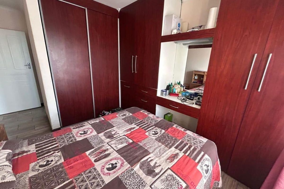 Bedroom featuring extensive built-in wooden cabinetry with integrated vanity and mirror, providing ample storage space.