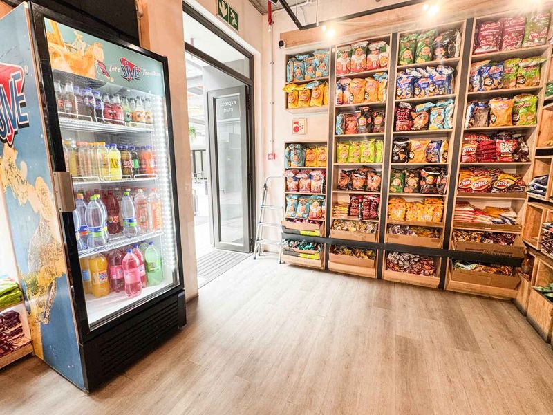 A retail utility space featuring built-in wooden shelving units for product display, laminate flooring, and a glass entrance door.
